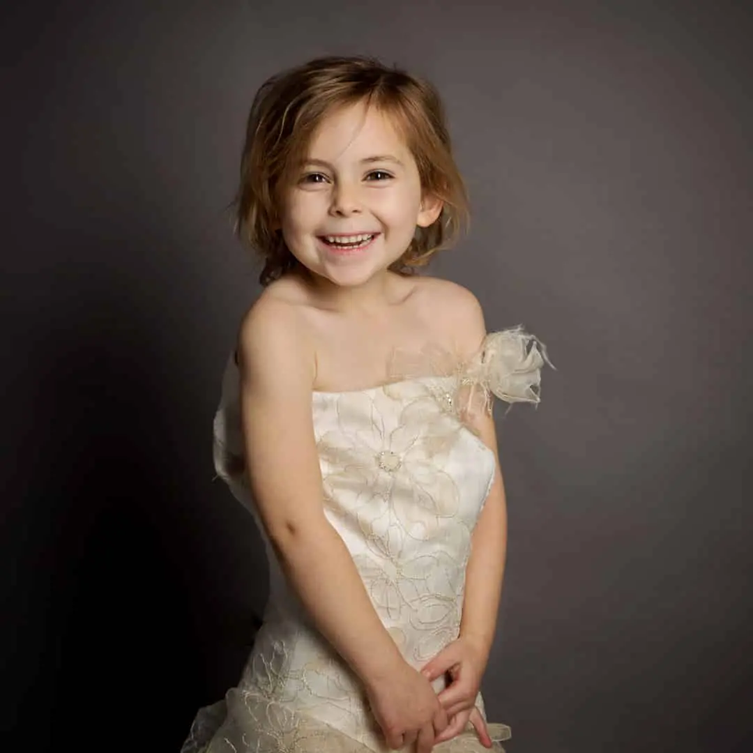 a little girl laughing in her mum's wedding dress