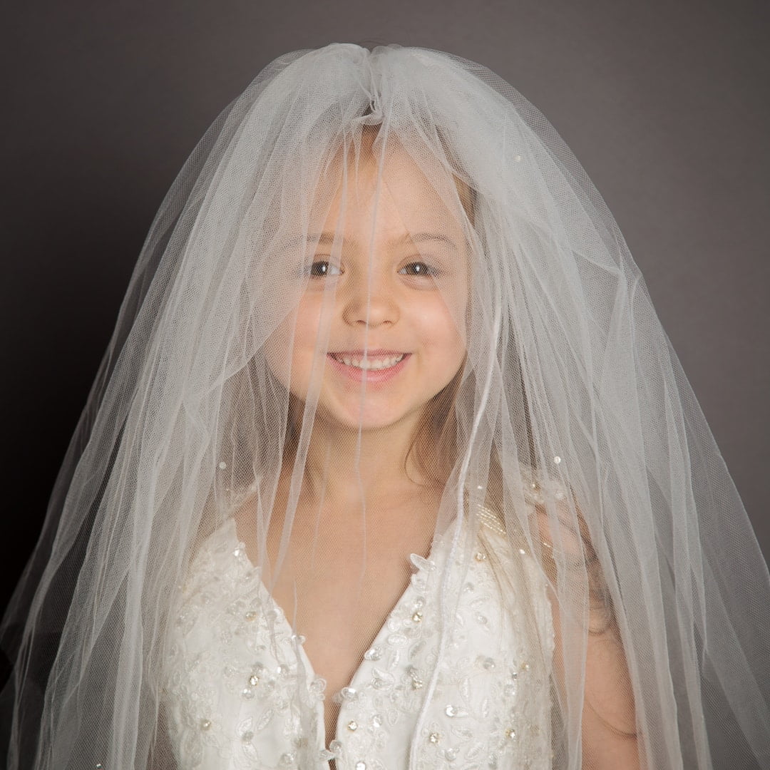 a little girl wearing her mum's wedding veil