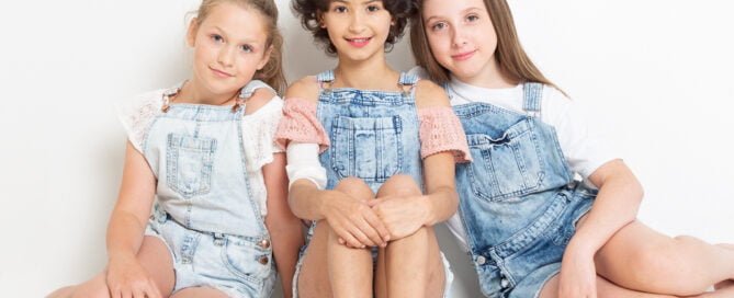 three young girls pose together as friends at portrait photo shoot in West Sussex