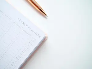 an image of a planner and a gold pen