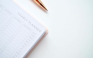an image of a planner and a gold pen