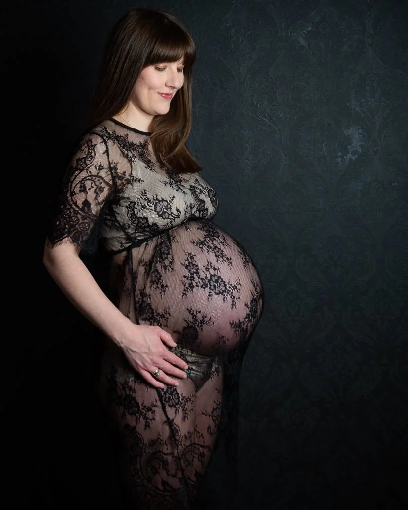 a pregnant lady in a black lace maternity dress