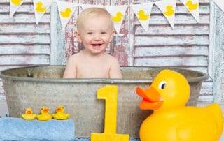 a duck themed tub splash photo shoot with rustic wood backdrop