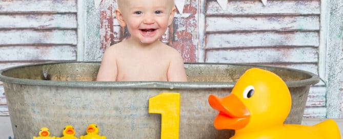 a duck themed tub splash photo shoot with rustic wood backdrop