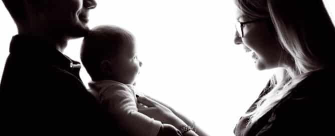 a mum and and dad pose in silhouette form in a black and white image