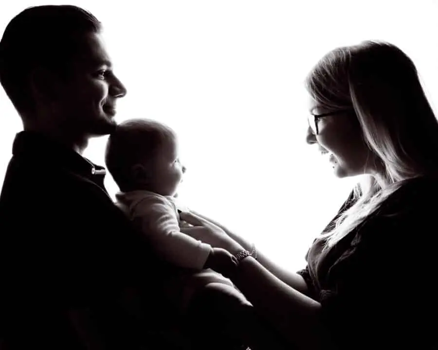 a mum and and dad pose in silhouette form in a black and white image