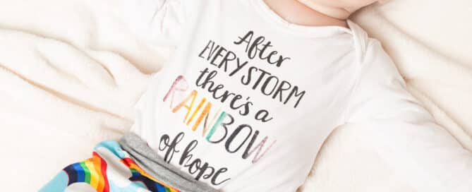 a little boy looking up at the camera in a rainbow themed outfit