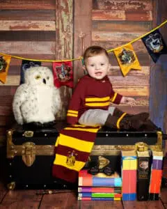 a little boy in a Harry Potter Quidditch outfit with Harry Potter themed props