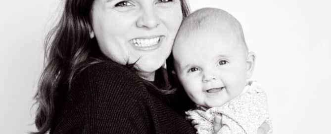 a mum poses with her daughter in a black and white professional portrait studio image against a white background