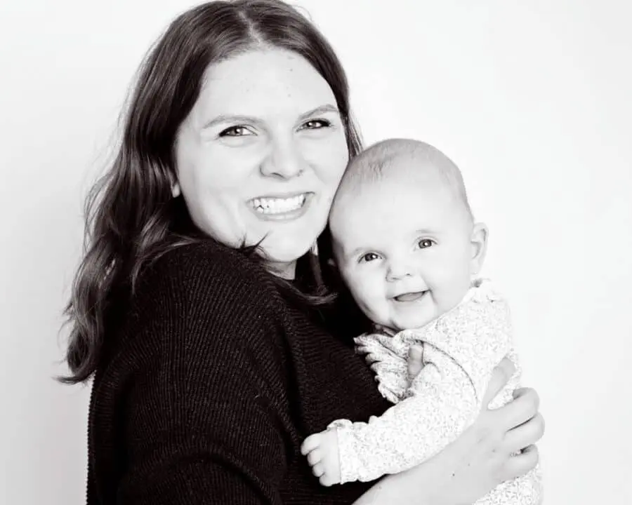 a mum poses with her daughter in a black and white professional portrait studio image against a white background