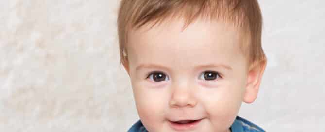a baby with brown eyes and spiky hair in the studio for a professional photo shoot