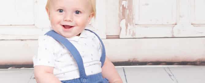 a little boy in a vintage styled blue and white outfit and long socks