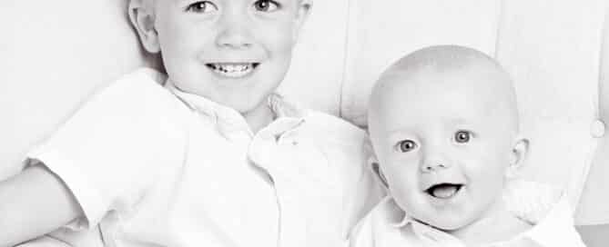 a black and white image of two boy siblings