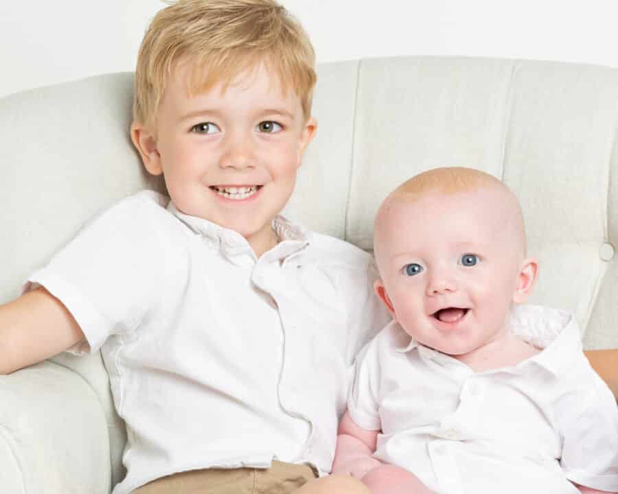 two brothers pose in matching white shirts