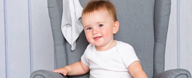 a little boy on a mini wingback chair with a favourite toy
