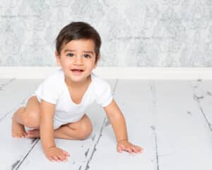 Baby Photography East Grinstead West Sussex a little boy in a white vest photographed against a blue damask background