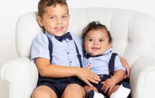 two brothers pose for professional family portraits in matching bow ties and braces