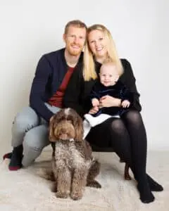a family of a mum, dad and baby girl pose with their family dog