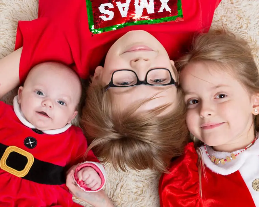 siblings pose in Christmas outfits for a professional photo shoot at my studio