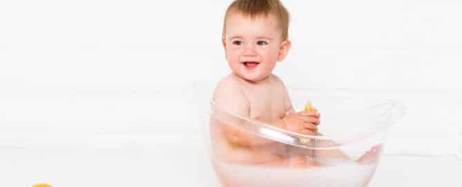 a little boy in a milk bath with some oranges in front of it
