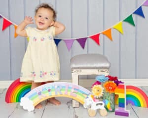 a little girl surrounded by rainbow props