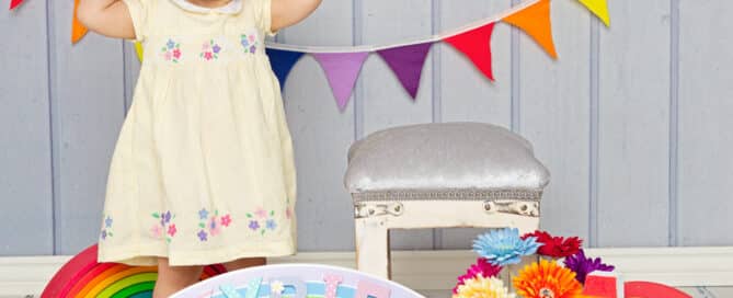 a little girl surrounded by rainbow props