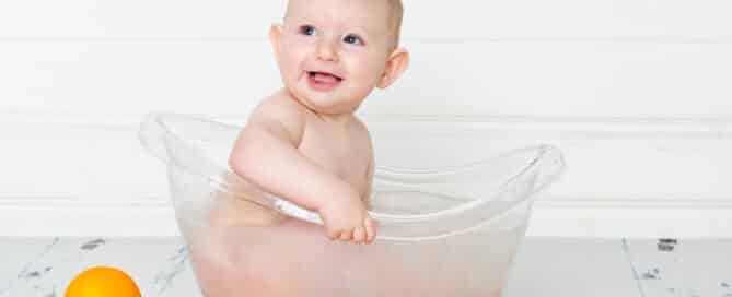 a little boy in a milk bath surrounded by oranges at a first birthday portrait session