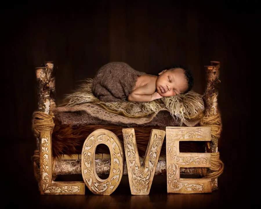 a little boy sleeps on a fur covered bed in a digital newborn composite image
