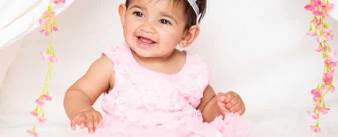 a little girl in a pink dress wears a silver tiara