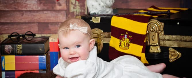 a little girl in a white dress amongst Harry Potter props