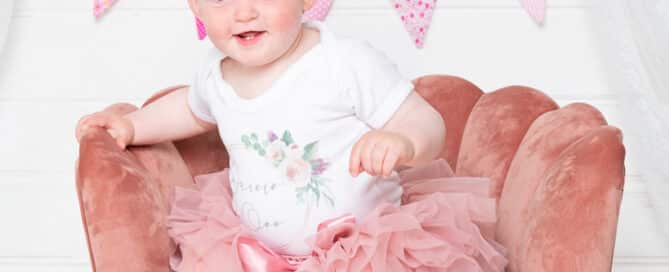 a little girl plays on a pink chair a photo shoot