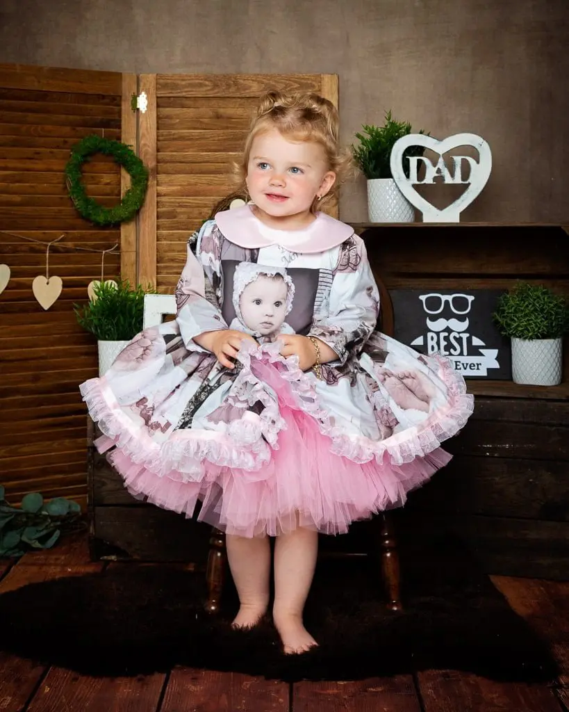 Father’s Day Mini Photo Shoots Studio West Sussex a little girl in a dress iwth photos printed on it at my father's day photo shoot in 2022