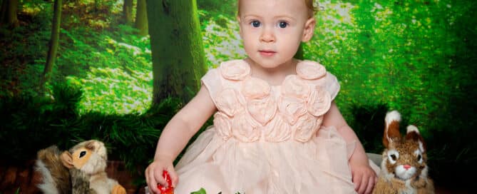 a little girl in a woodland styled studio setting