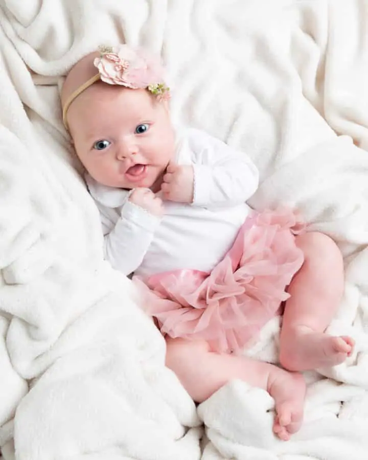 an older newborn baby at a professional photo shoot in a pink tutu