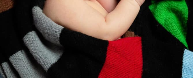newborn sleeps wrapped in a harlequins jersey