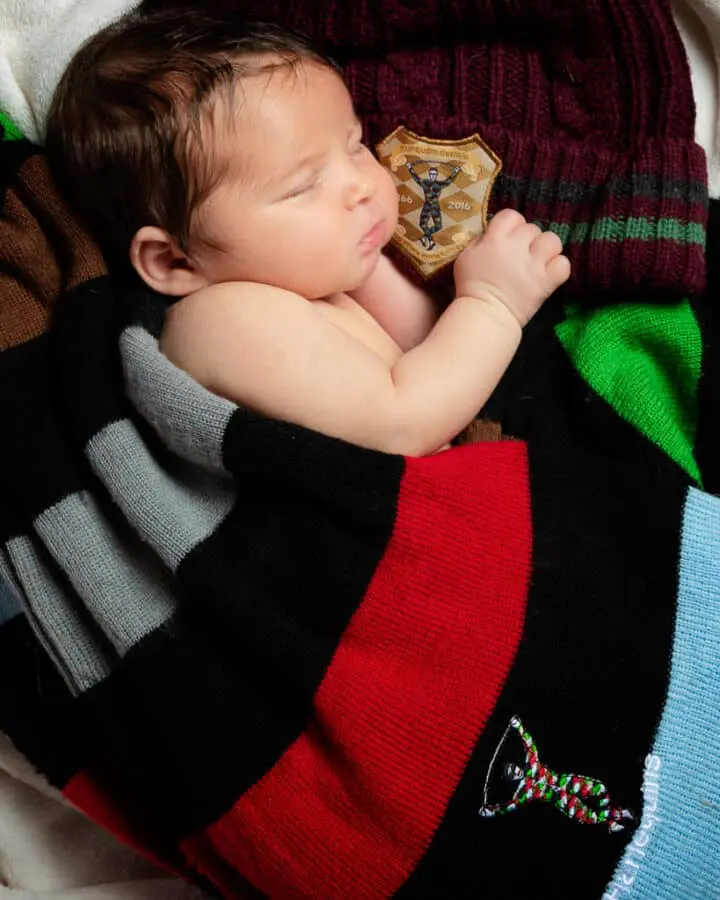 newborn sleeps wrapped in a harlequins jersey