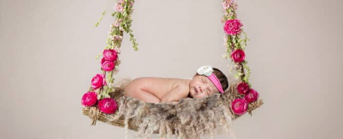 a digital image of a baby sleeping on a rose swing wearing a pink headband