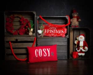 a dark wood set of crates with christmas ornaments make up a festive photo shoot set