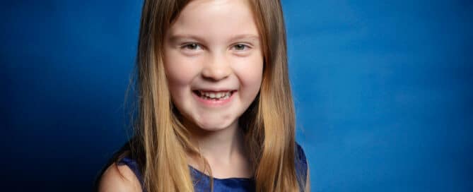 A young lady poses in a blue dress for a professional photo shoot