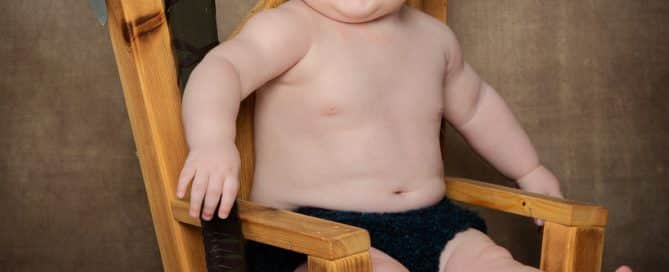 a little boy in a viking outfit on a wooden throne at a photo shoot