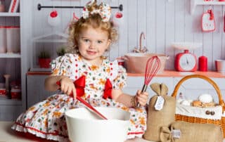 a little girl pretends to do some christmas baking at a photo shoot