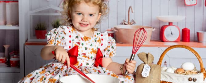 a little girl pretends to do some christmas baking at a photo shoot