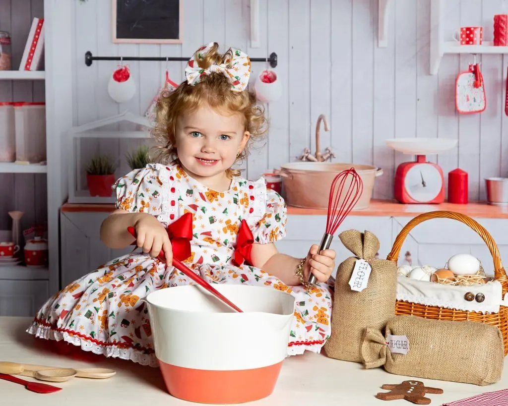 a little girl pretends to do some christmas baking at a photo shoot