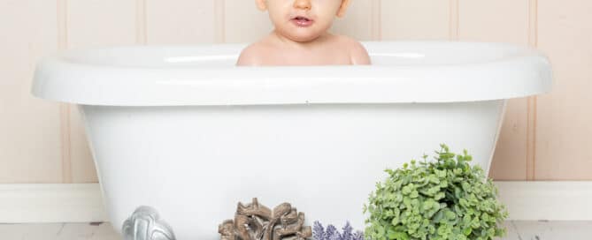 a little girl in a white bathtub with the love and lavender accessories