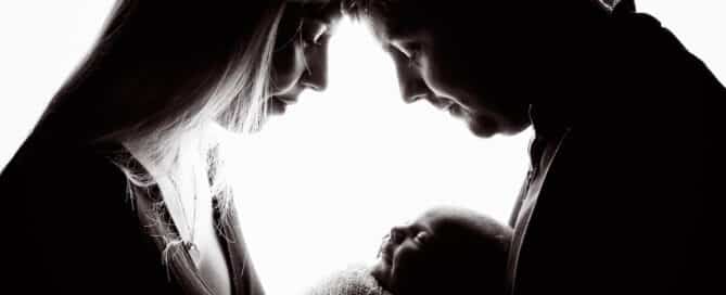a silhouette image of a family and newborn