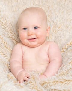 Baby Photography East Grinstead West Sussex a baby tucked up in a fluffy blanket