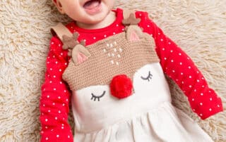 a little girl in a reindeer festive outfit