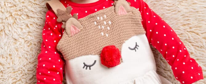 a little girl in a reindeer festive outfit