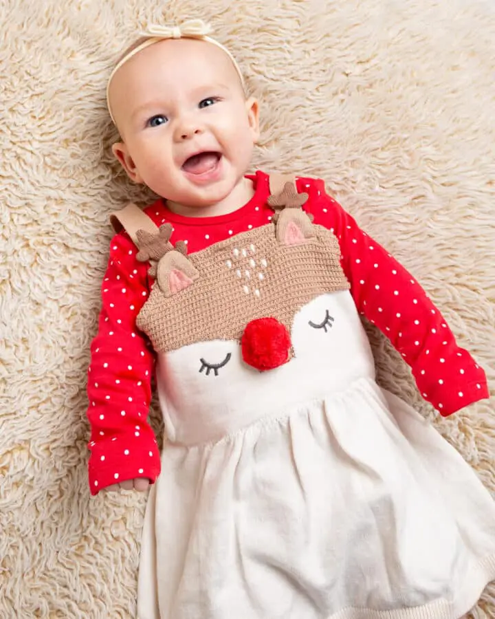 a little girl in a reindeer festive outfit