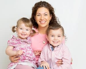 A family of three, a mother and two young children, pose smiling for a professional photo shoot image taken in my studio in East Grinstead